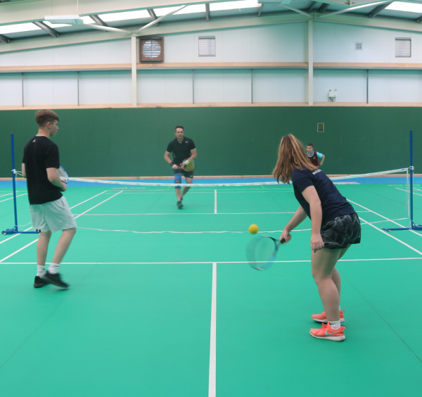 4 people playing short tennis